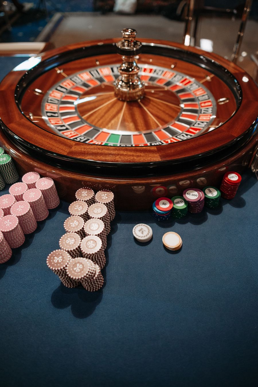 Susunan chip kasino dan roda roulette di meja permainan