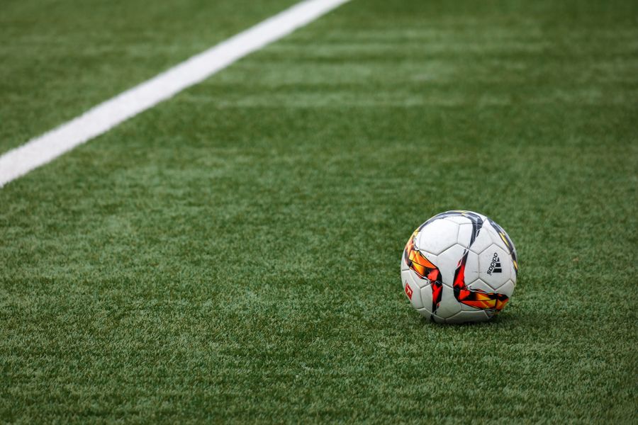 Stadion sepak bola dengan lapangan hijau saat malam pertandingan